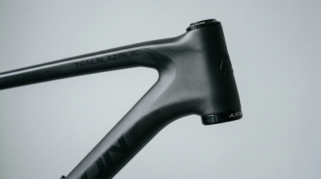 Close-up of a lightweight carbon fiber hardtail mountain bike frame in a studio setting.
